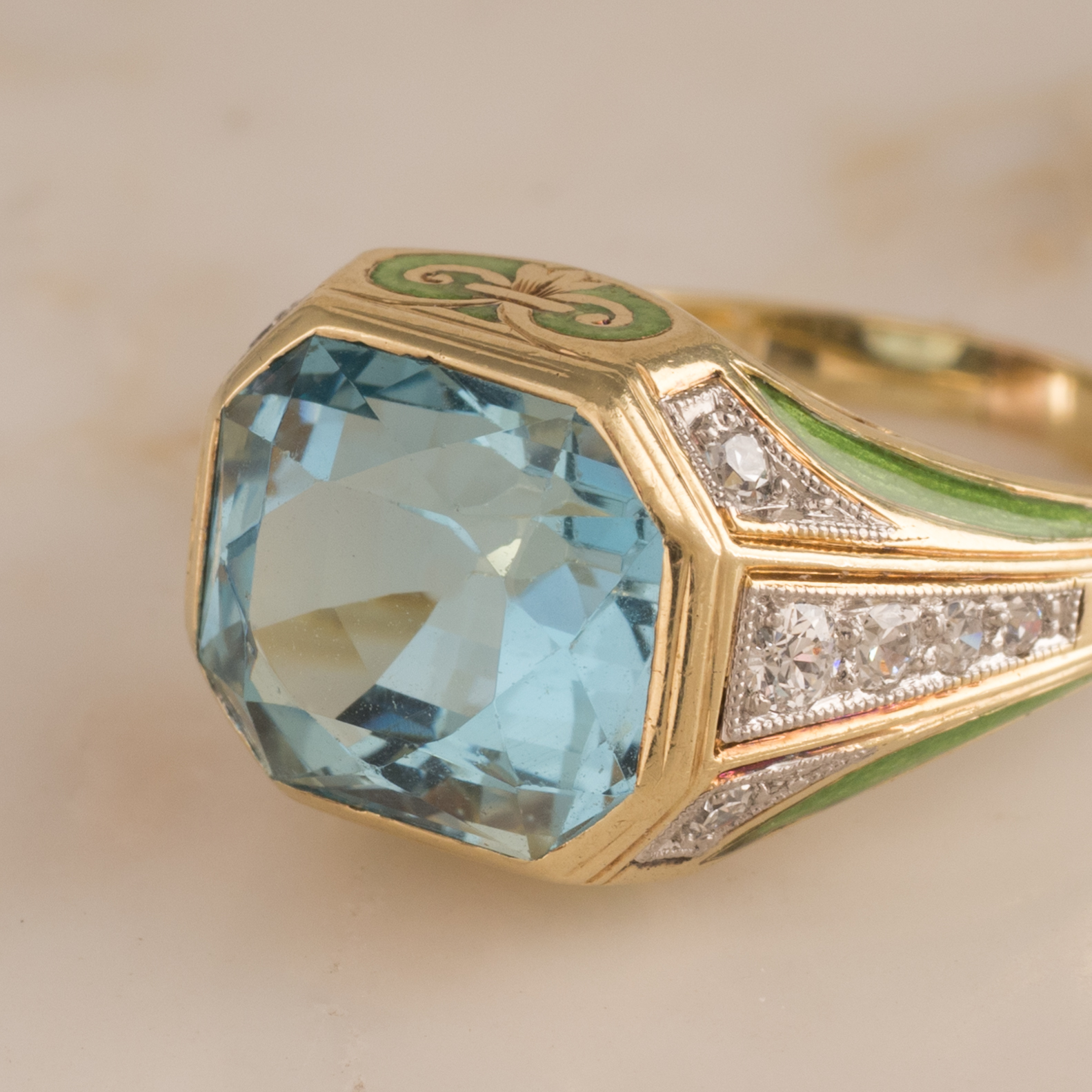14ct yellow gold ring with a faceted emerald cut aquamarine of estimated weight 5.00ct set horizontally in an octagonal solid sided mount with grain set single and brilliant cut shoulder diamonds and green enamel features on a plain polished band. Total Estimated Aquamarine Weight: 5.00ct Total Estimated Diamond Weight: 0.22ct Colour H Clarity VS-SI Weight: 5.70grams Age: C1910